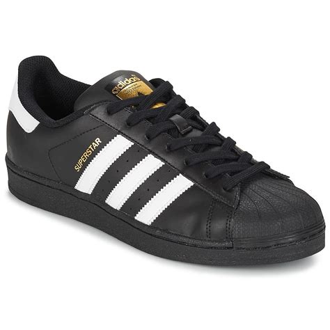 zwarte adidas sneaker met witte neus onder rok